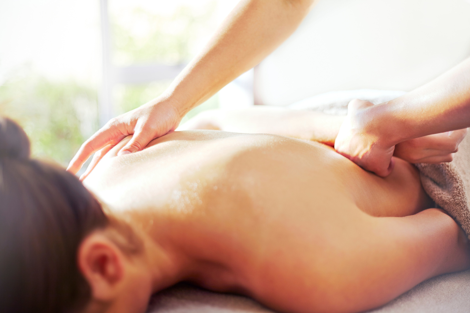 Masseuse massaging womans back
